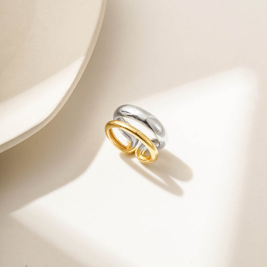 Gold and silver ring with intertwined bands, featuring a smooth and polished finish