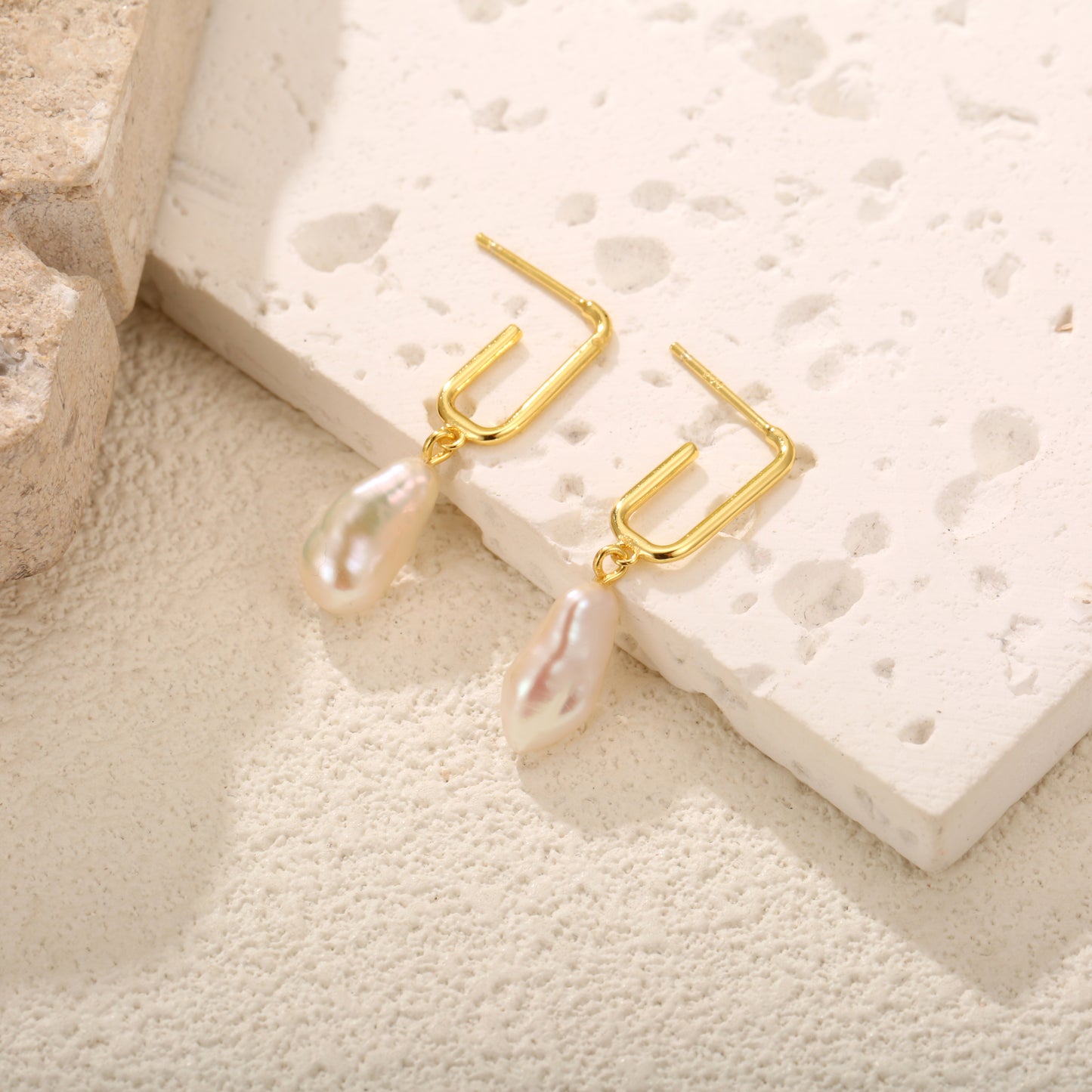 Delicate gold vermeil stud earrings with a modern rectangular design and dangling freshwater pearls