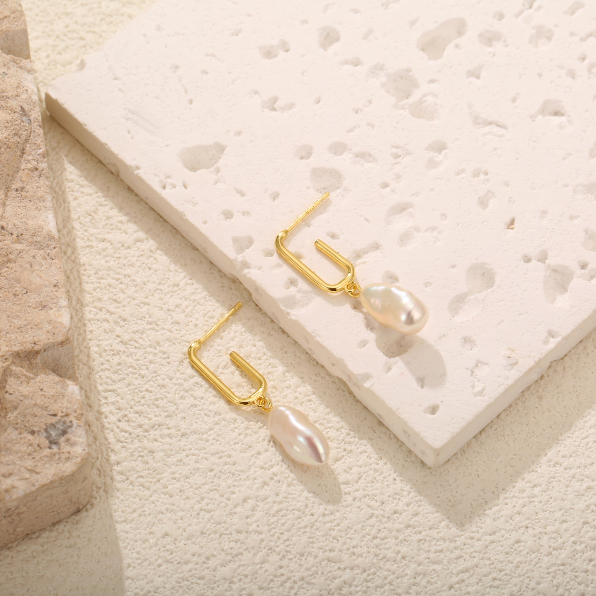 Delicate gold vermeil stud earrings with a modern rectangular design and dangling freshwater pearls