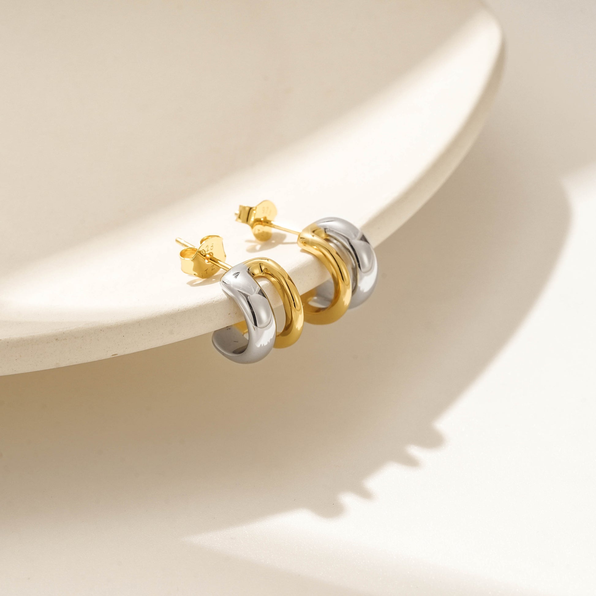 Two-tone gold vermeil stud earrings with a sleek, modern design